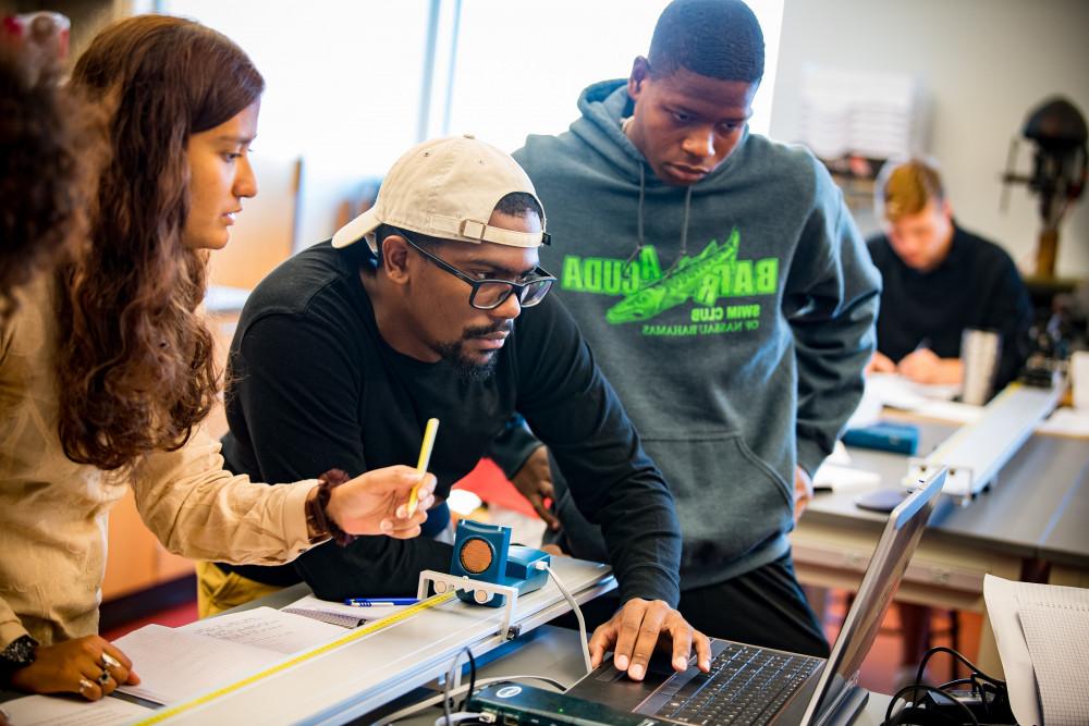 A group of students collaborate on a physics project in class.